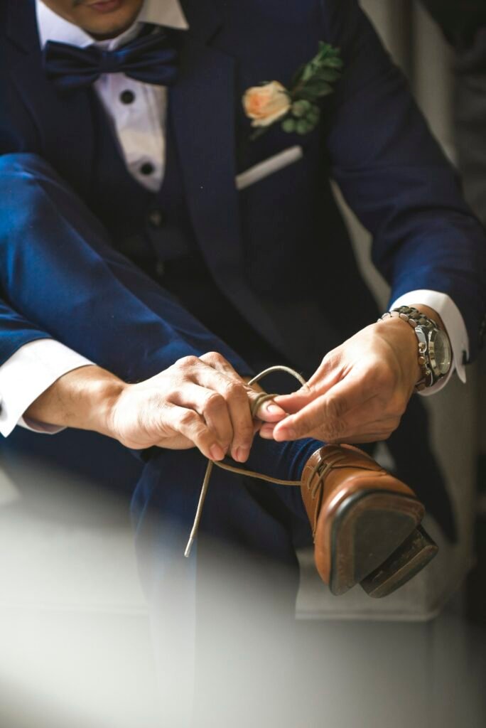 Groom fastening his dress shoes before the ceremony